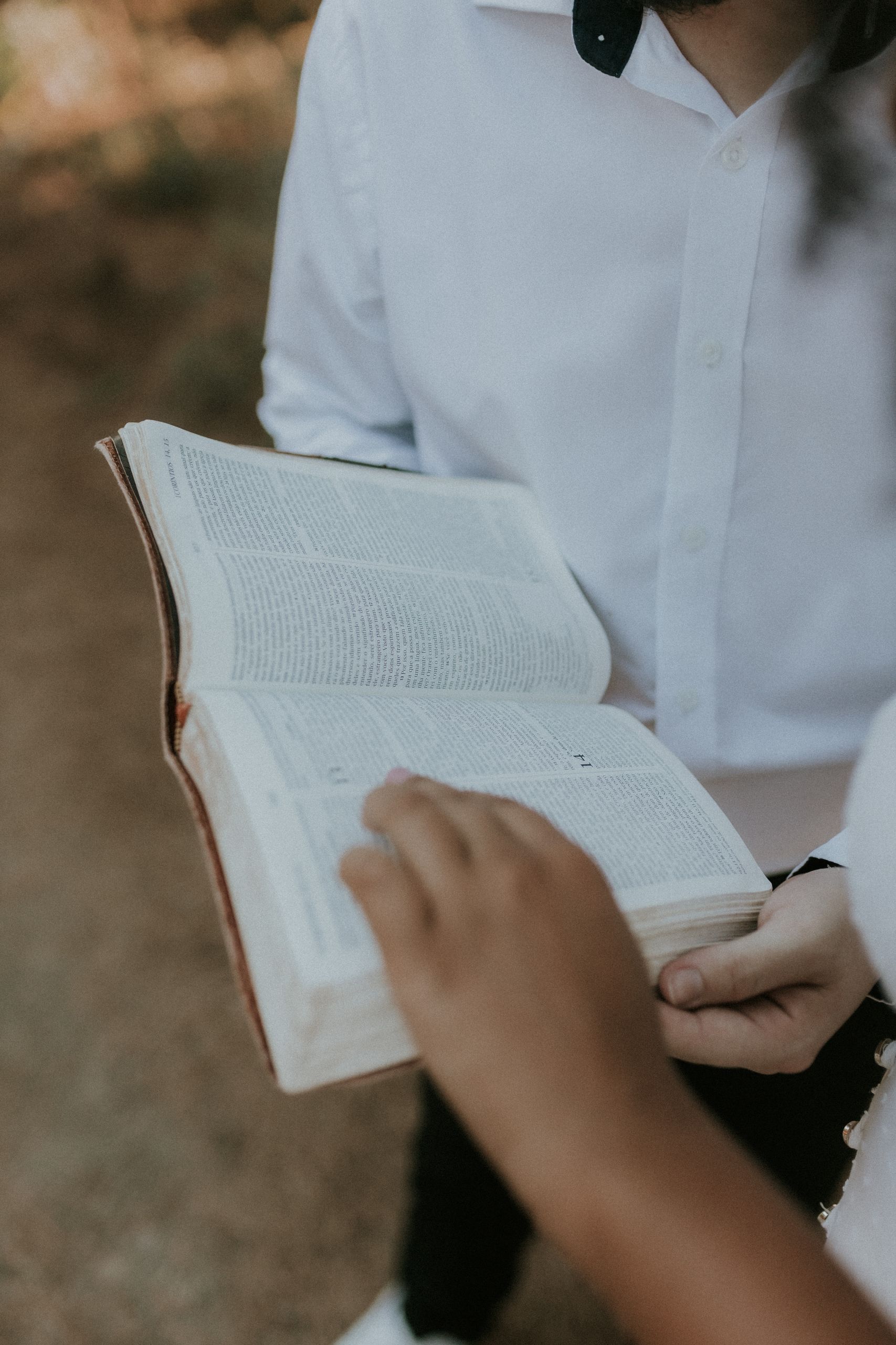 A couple sharing a moment reading the Bible outdoors, depicting unity and spirituality.