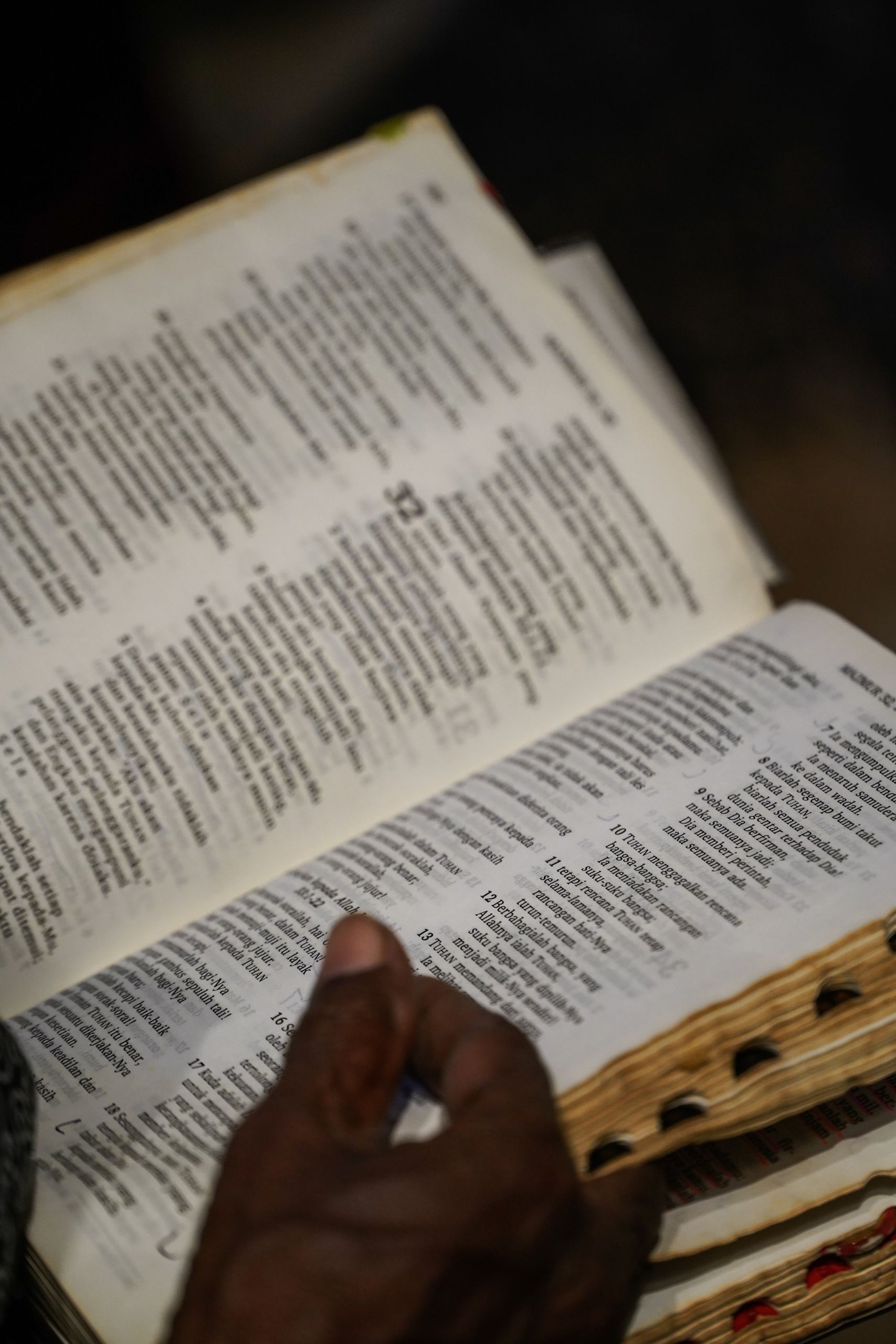 Close-up of a person engaging in Bible study, with focus on an open page.