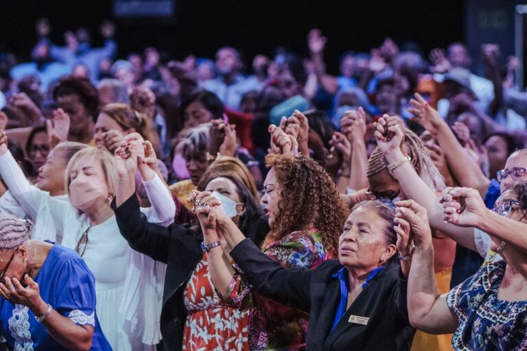 A diverse group of people in a heartfelt spiritual gathering, holding hands in unity.